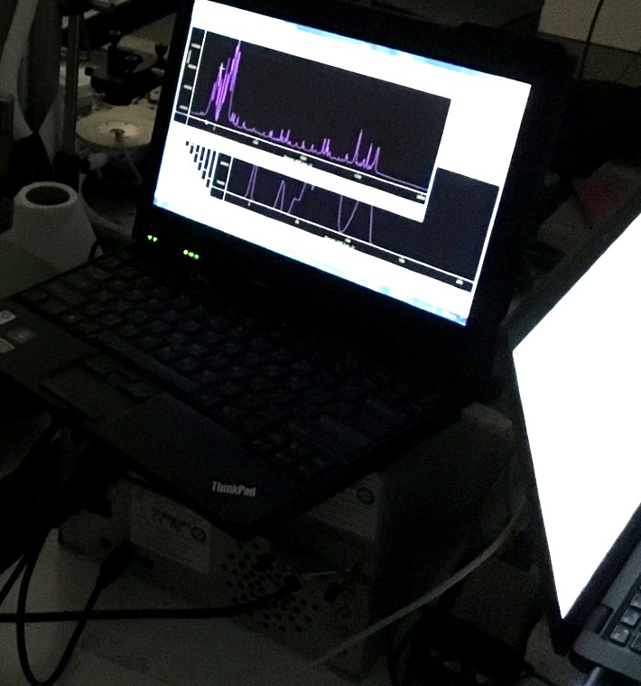 Spectral data shown on a computer screen next to an optical setup